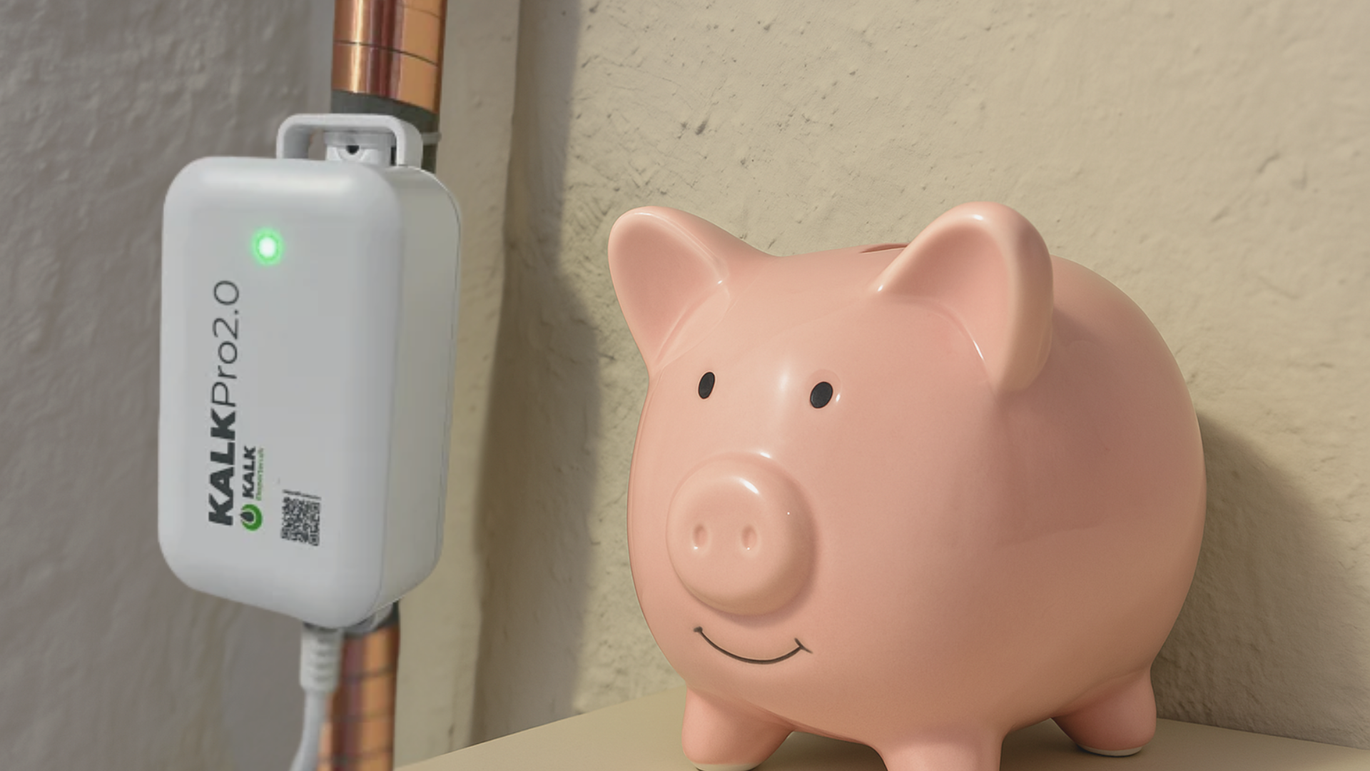 KalkPro 2.0 på kobberrør ved siden af en lyserød sparegris – illustrerer sparede udgifter og forebyggelse af kalkaflejringer i hjemmet