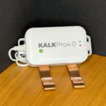 KalkPro 4.0 industri‑enhed på træbord – elektronisk kalkspalter med kobberbånd, der forebygger kalkaflejringer